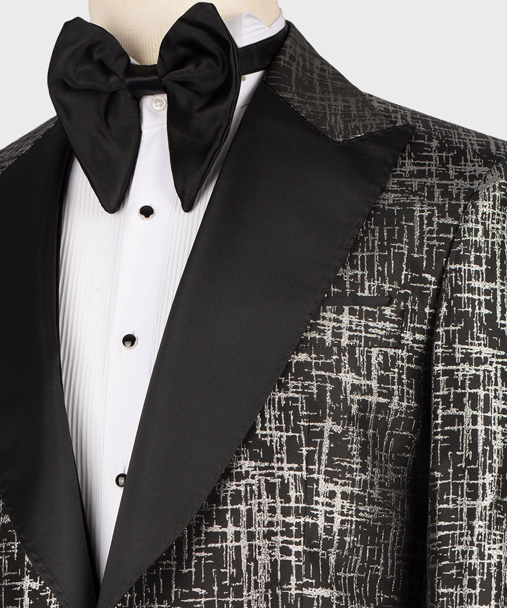 Close-up of black bow tie and pointed satin lapel on textured tuxedo jacket
