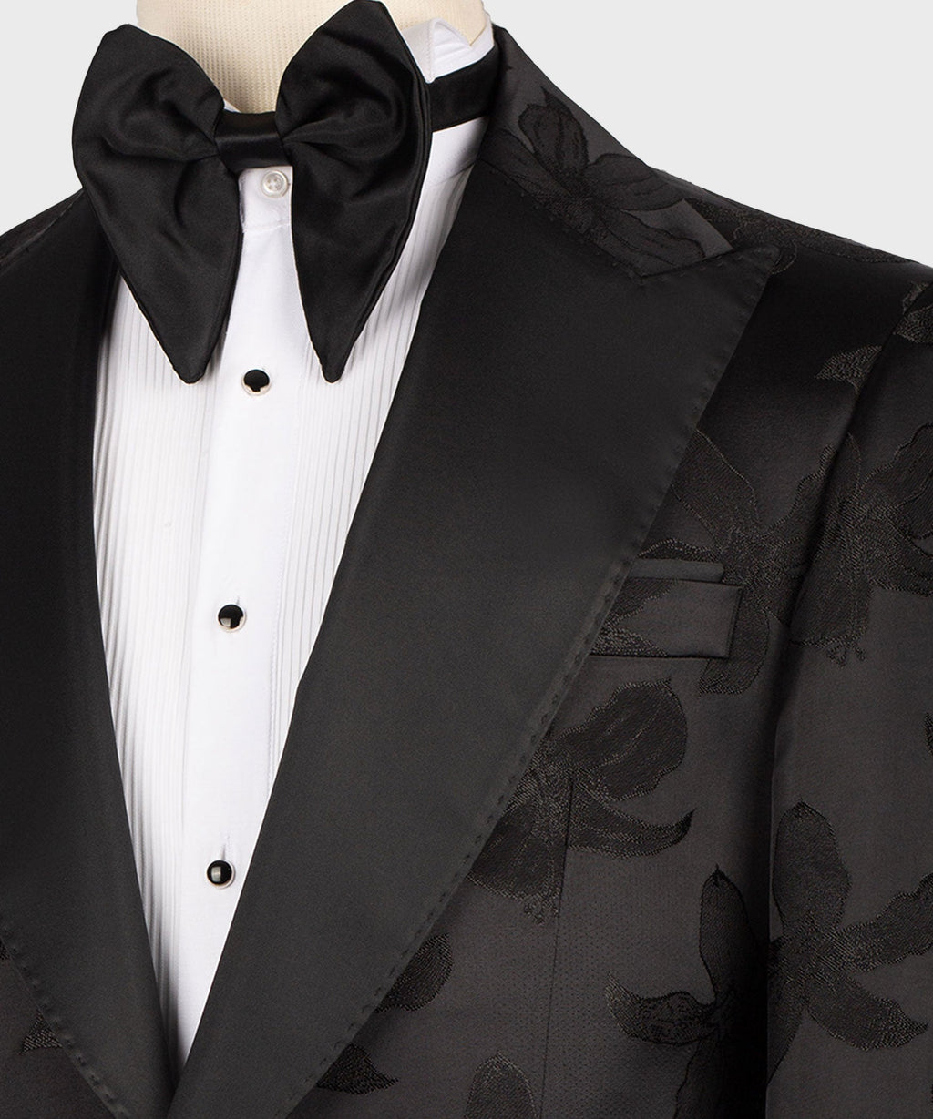 Close-up of black bow tie, white dress shirt placket, and satin tuxedo lapel