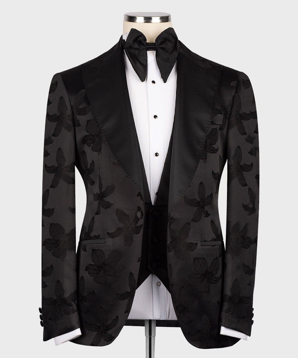 Black pointed-collar tuxedo set with bow tie, floral jacquard jacket, and buttoned vest