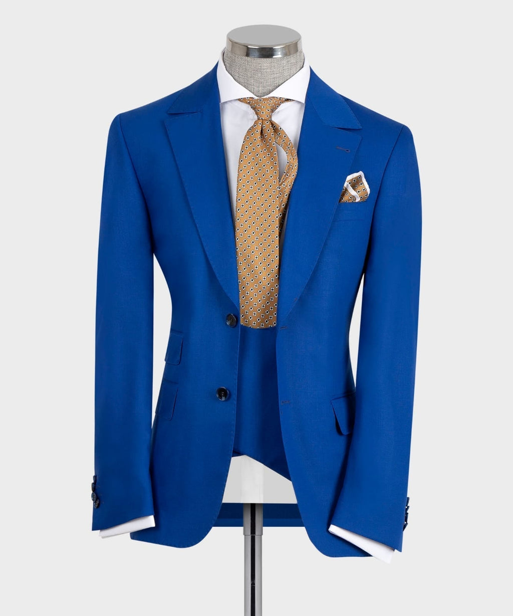 Blue suit jacket with vest, white shirt, gold patterned tie, pocket square