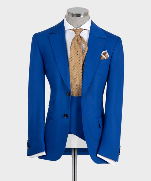 Blue suit jacket with vest, white shirt, gold patterned tie, pocket square