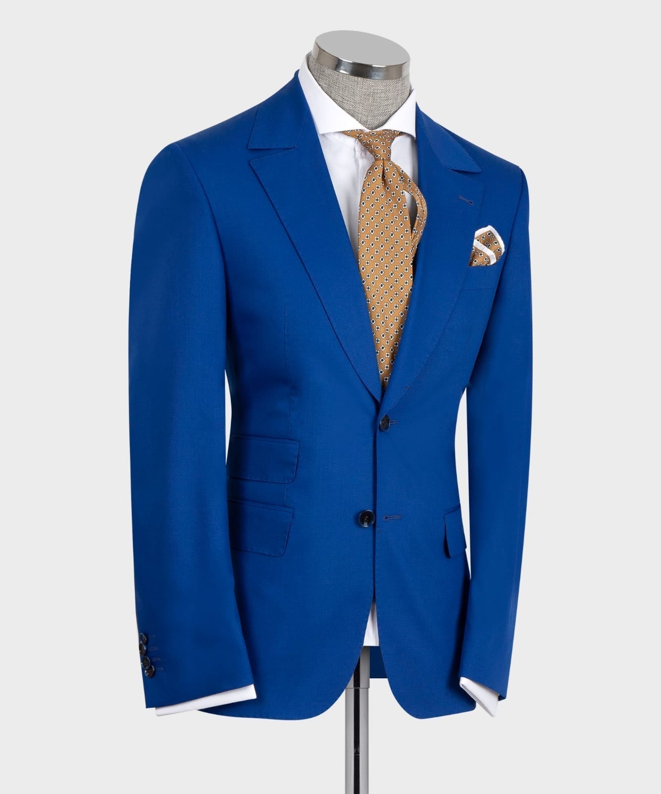 Blue three-piece suit jacket with vest, white shirt, gold patterned tie