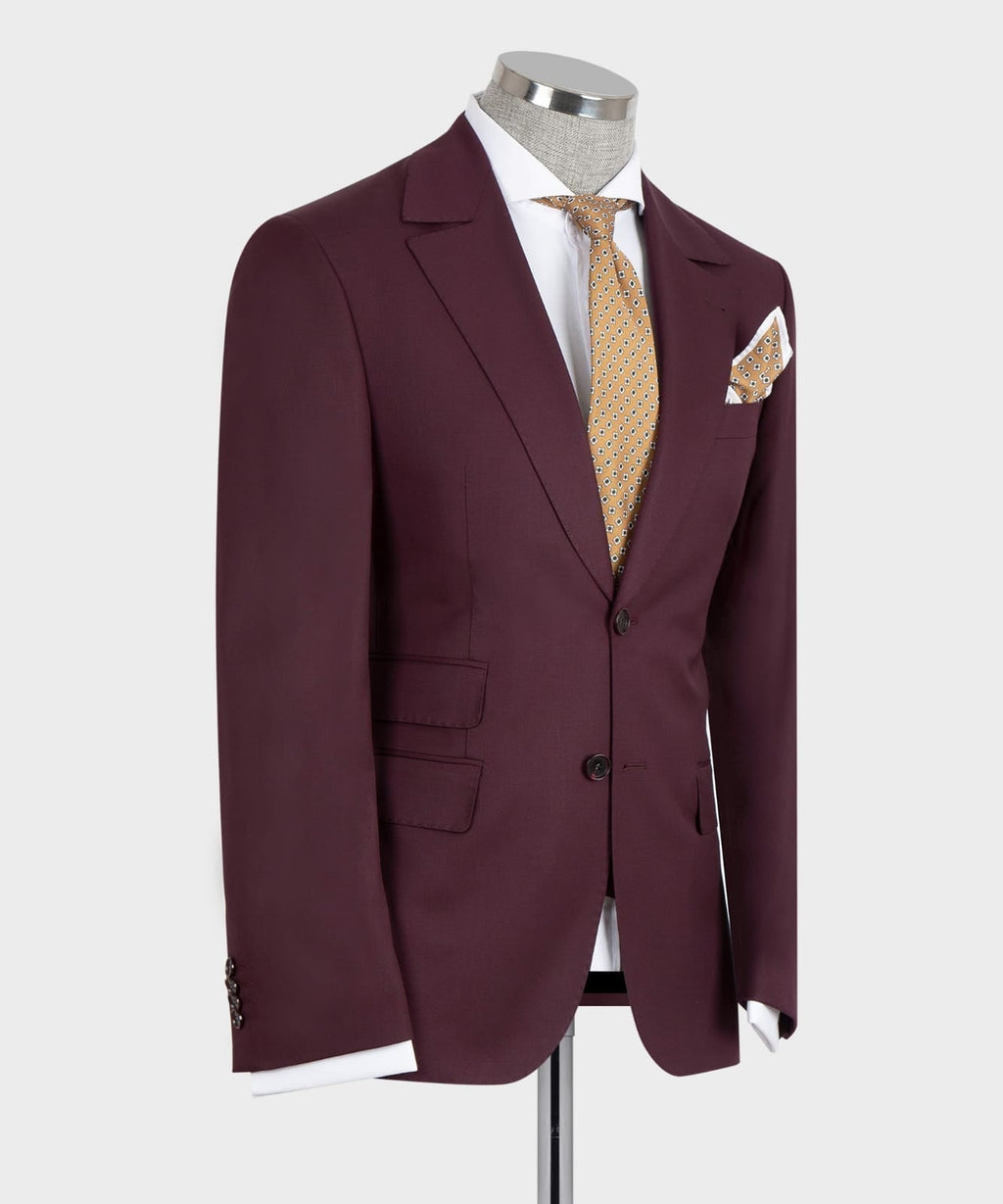 Burgundy suit jacket, open view over dark vest with gold patterned tie and chest pocket