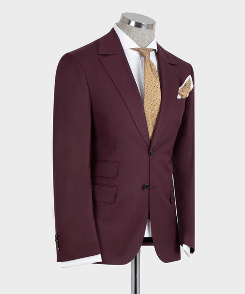 Burgundy suit jacket, open view over dark vest with gold patterned tie and chest pocket